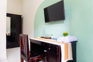 a living room with a tv on a wall at Behomy Harita Lampung in Geruntang +7 photos