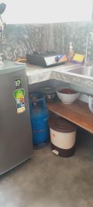 a kitchen with a counter and a sink and a refrigerator at Villa Koratuwa in Ahangama