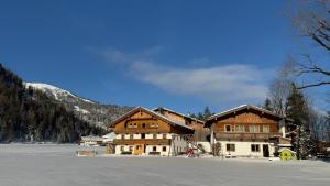a large building with snow in front of a mountain at Stiedlhof in Achenkirch