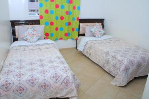 a bedroom with two beds and a colorful wall at BOUZNIKA Piscine et plage in Bouznika +24 photos