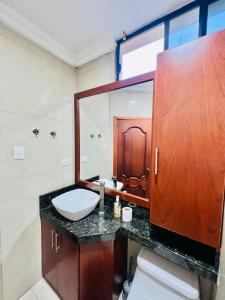 Un baño con lavabo, inodoro y espejo. en Suite cómoda, en Machala