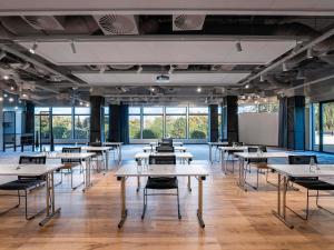 a large room with tables and chairs and windows at Novotel Gdańsk Marina in Gdańsk +160 photos
