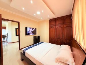 Un dormitorio con una cama grande y un espejo. en Suite cómoda, en Machala