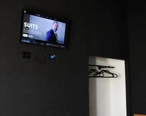 einen Flachbild-TV an einer Wand neben einer Tür in der Unterkunft Appartamenti "UNIQUE" palazzo storico FAENZA in Faenza