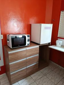 a microwave and a refrigerator on top of a counter at Air conditioning, TV and free parking - Bathroom in Cuiabá