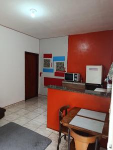 a kitchen with a table and a counter with a microwave at Air conditioning, TV and free parking - Bathroom in Cuiabá