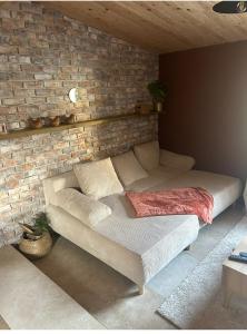 a bed in a room with a brick wall at Gite Chez Tof et Ninie in Houlle