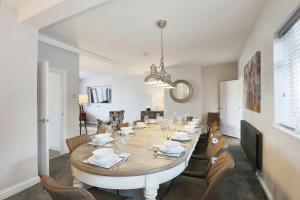 a dining room with a large table and chairs at Luxurious 7-Bedroom Home in Solihull, close to NEC & BHX in Solihull