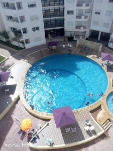 an overhead view of a large swimming pool with umbrellas at BOUZNIKA Piscine et plage in Bouznika