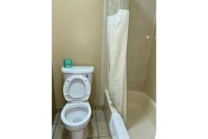 un baño con inodoro y bañera en Golden Inn Dallas by Hotel O, en Dallas 21 fotos más