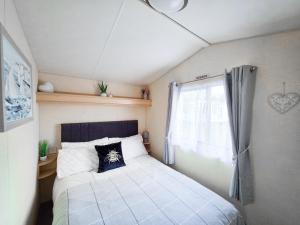 ein kleines Schlafzimmer mit einem Bett und einem Fenster in der Unterkunft Ocean Breeze in Truro