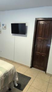 a bedroom with a flat screen tv on a wall at Nueva Acrópolis Sede SPS in San Pedro Sula