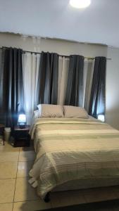 a bedroom with a large bed with black curtains at Nueva Acrópolis Sede SPS in San Pedro Sula