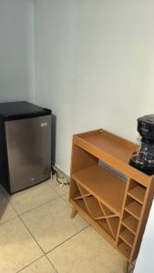 a kitchen with a tv and a wooden cabinet at Nueva Acrópolis Sede SPS in San Pedro Sula
