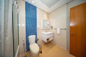 ドバイにあるCity Stay Grand Hotel Apartments - Al Barshaの青い壁のバスルーム(白いトイレ付)