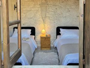 a bedroom with two beds and a lamp on a night stand at Levanda House - Traditional House Vasa Koilaniou in Vasa Kilaniou