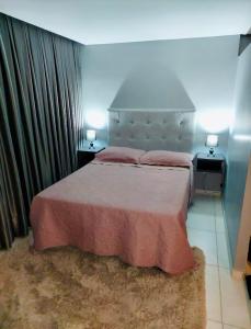 a bedroom with a large bed with two night stands at Flat perto do MAR in Cabedelo