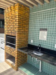 a bathroom with a sink and a brick fireplace at Flat perto do MAR in Cabedelo