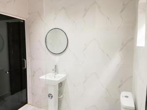 ラゴスにあるLuxe Apartments Surulereの洗面台と壁に鏡が付いたバスルーム