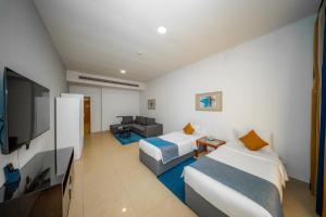 ドバイにあるCity Stay Grand Hotel Apartments - Al Barshaのベッド2台と薄型テレビ付きのホテルの部屋