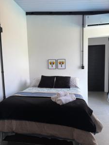 a bedroom with a bed with two towels on it at Serra&Mar in Osório