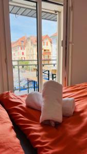 a bed with towels on it with a large window at Cresta Apartment in St. Gallen