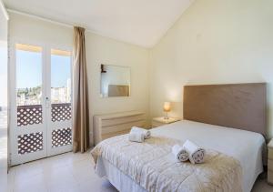 a white bedroom with a bed and a balcony at Marina Plaza by Garvetur in Vilamoura