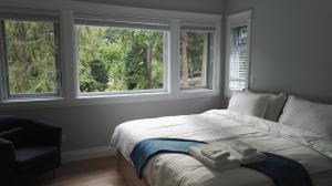 a bedroom with a bed with two towels on it at Riverfront Bed and Breakfast in North Vancouver