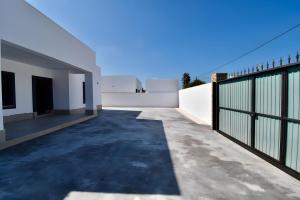 ein Blick auf ein Haus mit einem Zaun in der Unterkunft Villa Private Oasis in Chiclana de la Frontera