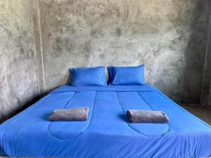 a blue bed with two pillows on top of it at The Poom Garden Khao Yai in Ban Khanong Phra Klang (1)