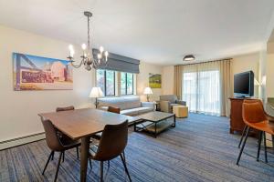 ラトランドにあるBest Western Inn & Suites Rutland-Killingtonのダイニングテーブルとソファのあるリビングルーム