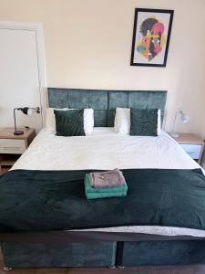 Un dormitorio con una cama grande con cabecero verde. en Apartment 2- 216 High Street, en Arbroath