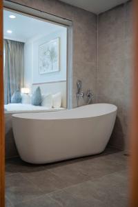 a white bath tub in a bathroom with a bedroom at Maison Lake View Luang Prabang in Luang Prabang +16 photos
