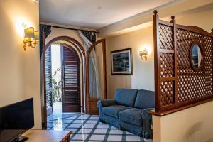 een woonkamer met een blauwe bank en een entree bij Garibaldi Houses in Milazzo