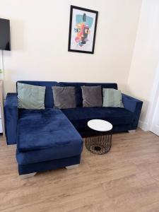Un sofá azul en una sala de estar con una mesa. en Apartment 2- 216 High Street, en Arbroath