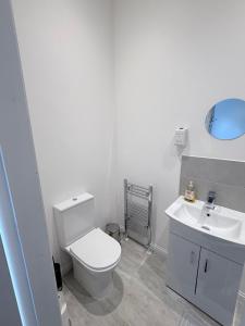 Un baño con un inodoro blanco y un lavabo. en Apartment 2- 216 High Street, en Arbroath