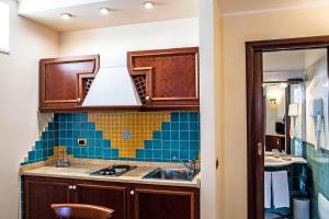 een keuken met houten kasten en een spoelbak bij Garibaldi Houses in Milazzo +52 foto's