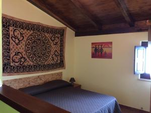 a bedroom with a bed and a picture on the wall at Il Muraglio in Belmonte Calabro