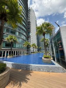 a large swimming pool with palm trees in a city at vortex luxury apartment klcc in Kuala Lumpur