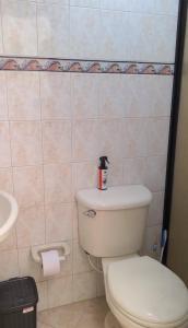 a bathroom with a white toilet and a sink at Nina House, Cali, Valle del Cauca in Cali