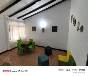 a dining room with a table and green chairs at Nina House, Cali, Valle del Cauca in Cali +1 photo
