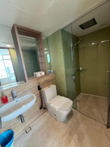 a bathroom with a toilet and a sink and a shower at vortex luxury apartment klcc in Kuala Lumpur +54 photos