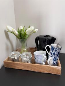 a wooden tray with a vase of flowers and cups at Hoeve Herweijer in Strijensas