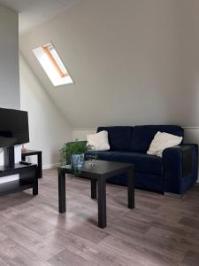 a living room with a blue couch and a coffee table at Hoeve Herweijer in Strijensas