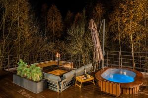 Ein Whirlpool auf einer Terrasse mit Sofa und Sonnenschirm in der Unterkunft Ramiau - su gamta in Kareivonys