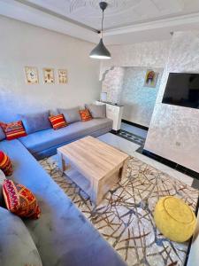 a living room with a blue couch and a coffee table at A12 Studio cosy Tamraght Idéal nomades & surfers in Tamraght Ouzdar