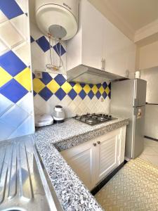 a kitchen with a stove and a refrigerator at A12 Studio cosy Tamraght Idéal nomades & surfers in Tamraght Ouzdar