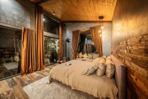 ein Schlafzimmer mit einem großen Bett und einem großen Fenster in der Unterkunft Ramiau - su gamta in Kareivonys