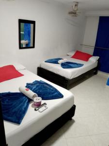 two beds sitting in a room with at Hotel Viajero Del Mar in Turbo