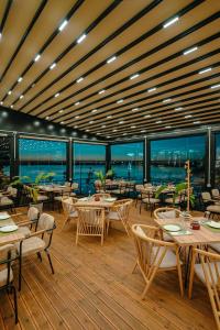 un restaurant avec des tables et des chaises sur une terrasse dans l'établissement Lumeris lakeview Suites and SPA, à Rubjekë